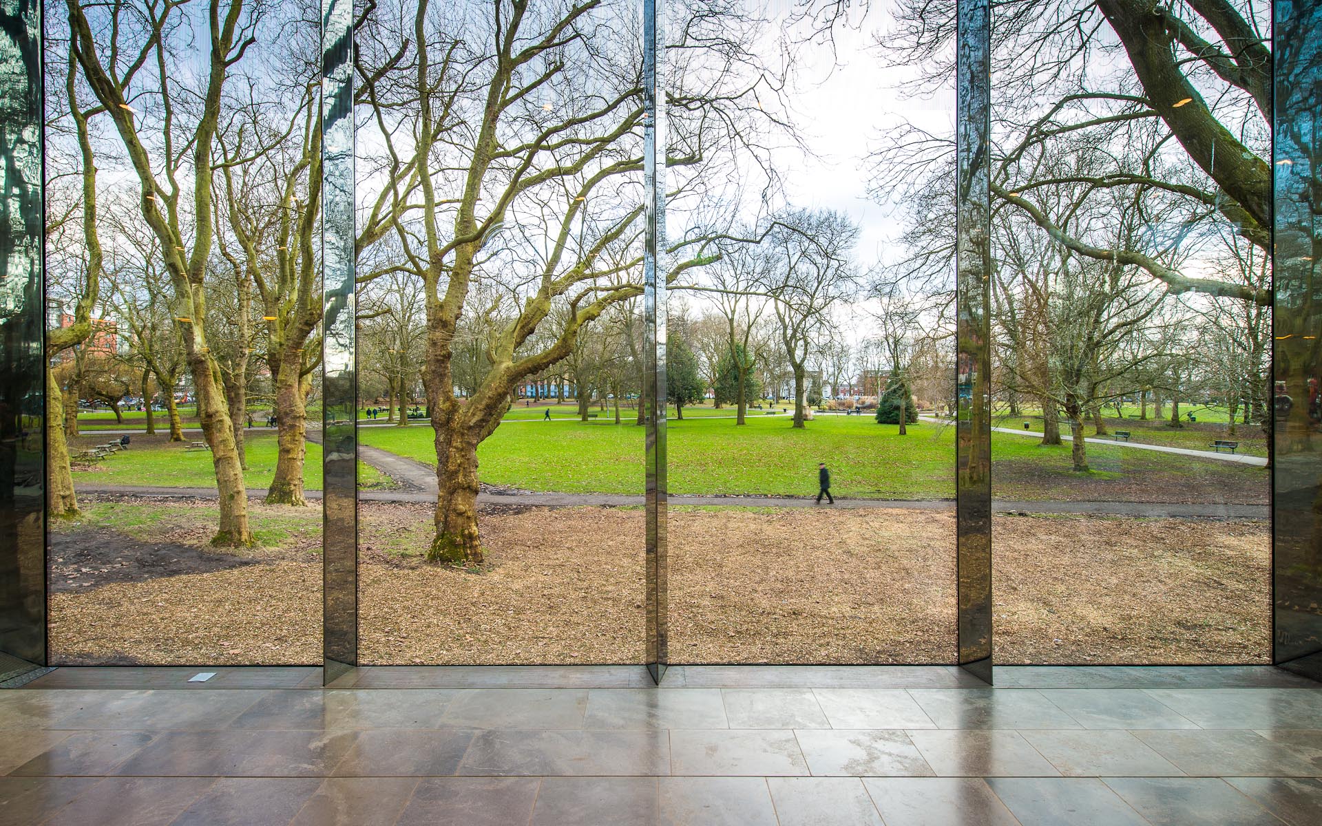 Interior daytime capture of Whitworth Art Gallery Manchester England glass panels view through to green park